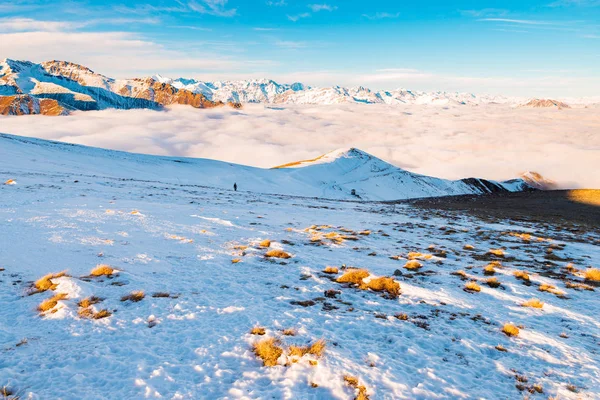 Malerische alpine Landschaft, Wolken im Tal arisign Berggipfel Sonnenuntergang Licht, Winter Schnee. — Stockfoto