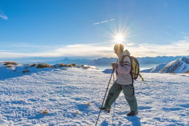Kadın backpacker Alpler karda doğa yürüyüşü. Arkadan görünüş, kış soğuk hissediyor, yaşam tarzı, arka ışık güneş yıldız.