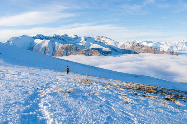 Backpacker piesze wycieczki na śniegu w Alpach. Widok z tyłu, lifestyle zima, zimno uczucie, majestatyczne góry. — Zdjęcie stockowe