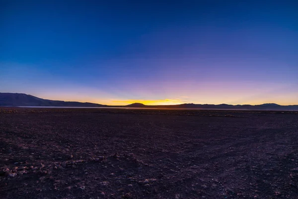 Das karge Hochland der Anden gehört zu den wichtigsten Reisezielen in Bolivien. Glühendes Gras bei Sonnenuntergang im Vordergrund mit majestätischen Vulkanausläufern im Hintergrund. — Stockfoto