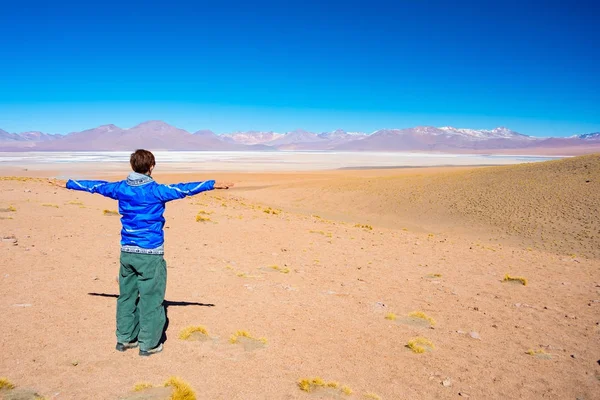 游客看着在安第斯山脉的咸冰冻湖泊令人惊叹的景观, 道路旅行著名的乌尤尼盐平坦, 旅游目的地在玻利维亚. — 图库照片