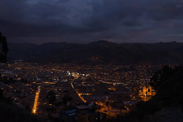 夕暮れ時に輝く街の明かりとクスコ市街のパノラマ風景。クスコはペルー、南アメリカで最も観光客向けの旅行先の中で、します。. — ストック写真