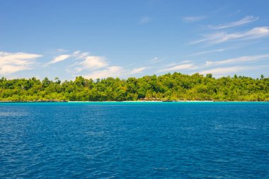 Adası'nın kayalık sahil adacıkları tarafından tespit ve merkezi Sulawesi, Endonezya uzak Togean Adaları (veya Togian Adaları), renkli deniz yoğun yemyeşil yeşil orman kapsadığı.