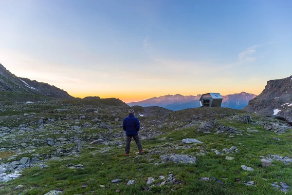 Una persona mirando el colorido amanecer en lo alto de los Alpes. Amplia vista angular desde arriba con brillantes picos de montaña en el fondo. Aventura de verano y exploración . — Foto de Stock