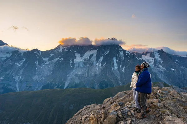 Un paio di persone che guardano l'alba sulla cima del Monte Bianco (4810 m). Valle d'Aosta, avventure estive italiane e meta di viaggio sulle Alpi . — Foto Stock