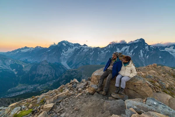 Couple of people looking at the sunrise over Mont Blanc mountain peak (4810 m). Valle d'Aosta, italian summer adventures and travel destination on the Alps. — Stock Photo, Image