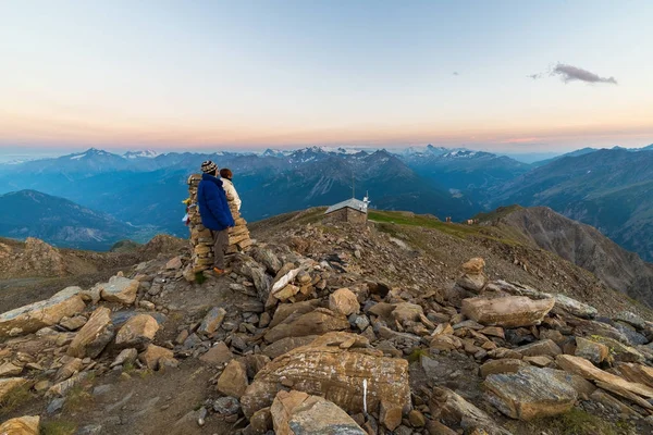 Couple of people looking at the sunrise over Mont Blanc mountain peak (4810 m). Valle d'Aosta, italian summer adventures and travel destination on the Alps. — Stock Photo, Image