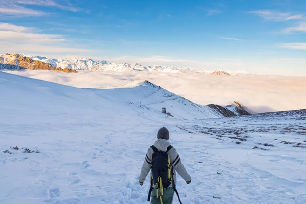 Backpacker piesze wycieczki na śniegu w Alpach. Widok z tyłu, lifestyle zima, zimno uczucie, majestatyczne góry. — Zdjęcie stockowe