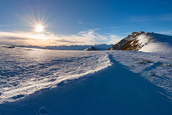 Montagne innevate in controluce, giorno luminoso e soleggiato inverno sulle Alpi, sole splendente sulle alte cime innevate . — Foto Stock