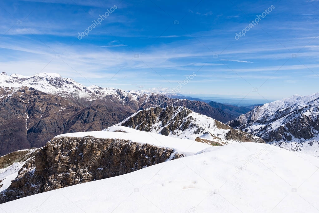 The Alps in winter, sunny day snow ski resort stunning view from top, high mountain peaks in the italian alpine arch.