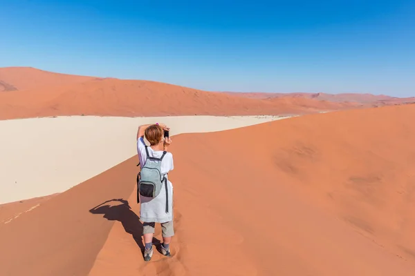 Tourist taking photo at Sossusvlei, Namibia. Scenic sand dunes, Namib desert, Namib Naukluft National Park, travel adventure in Africa. — Stock Photo, Image