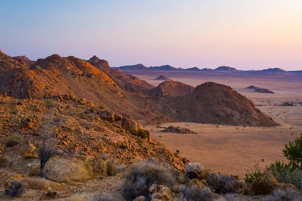 Deserto rochoso ao entardecer, pôr-do-sol colorido sobre o deserto da Namíbia, Namíbia, África, rochas brilhantes e cânion . — Fotografia de Stock