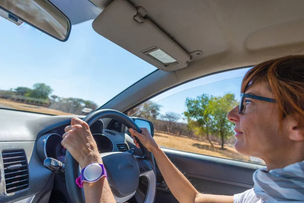 人们旅行的概念。妇女驾驶汽车与手方向盘。内部关闭, 一方面选择焦点, 侧面视图. — 图库照片