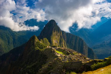 Machu Picchu açılış bulutlar çıkan güneş tarafından aydınlatılmış. En çok ziyaret edilen seyahat hedef Peru İnka'nın şehridir. Sis, bulutlar ve sis vadiyi kapsayan.