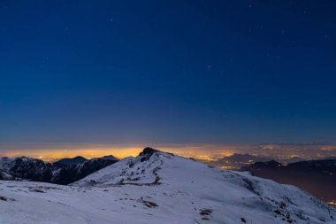 Turin şehir ışıkları, gece kar görünümünden ışığında Alps kaplı. Ay ve Orion takımyıldızı, açık gökyüzü. İtalya.