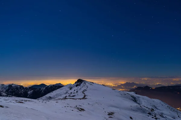 Luzes da cidade de Turim, vista noturna de Alpes cobertos de neve ao luar. Lua e constelação de Orion, céu limpo. Itália . — Fotografia de Stock