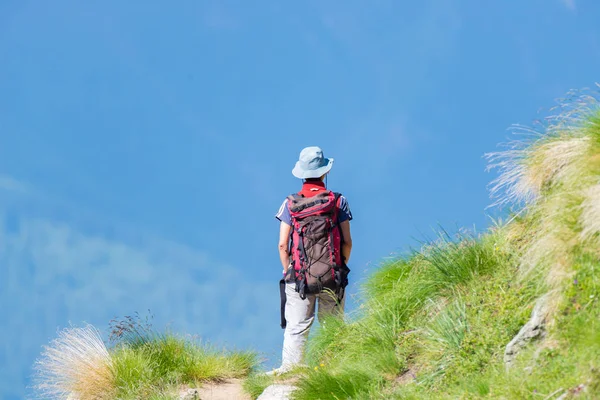 徒步旅行的背包客走在山上的远足小径。夏季冒险在阿尔卑斯山度假。癖人旅游理念. — 图库照片