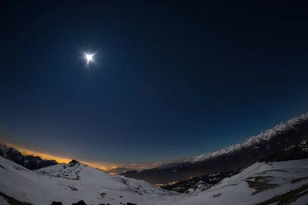 Luzes da cidade de Turim, vista noturna de Alpes cobertos de neve ao luar. Lua e Orion constelação, céu limpo, lente fisheye. Itália . — Fotografia de Stock