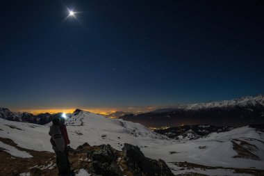 Ay ve yıldızlı gökyüzünün, Alpler, balıkgözü lens kar. Orion takımyıldızı, Betelgeuse ve Sirio. Uzun pozlama iki yürüyüşçü manzaraya, gece açık hava etkinlikleri seyir bulanık.