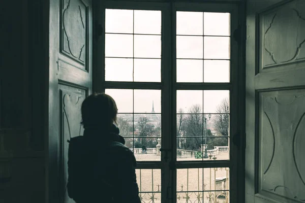 Γυναίκα ψάχνει μέσα από το παράθυρο, τονισμένο εικόνα, vintage στυλ. Τορίνο: αστικό τοπίο, Τορίνο, Ιταλία, παλιό σπίτι, πίσω όψη στη σκιά. — Φωτογραφία Αρχείου