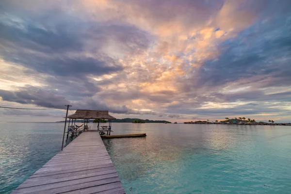 Plage tropicale, mer des Caraïbes, eau turquoise transparente, îles éloignées du Togean (îles Togiennes), Sulawesi, Indonésie. Ciel dramatique au coucher du soleil . — Photo