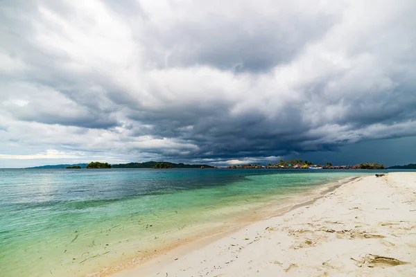 Plage tropicale, mer des Caraïbes, eau turquoise transparente, îles éloignées du Togean (îles Togiennes), Sulawesi, Indonésie. Ciel dramatique au coucher du soleil . — Photo