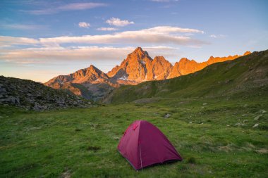 Çadır Alps.Snowcapped Sıradağları ve renkli gökyüzü günbatımı kamp. Macera ve keşif, sıkıntı fetih.