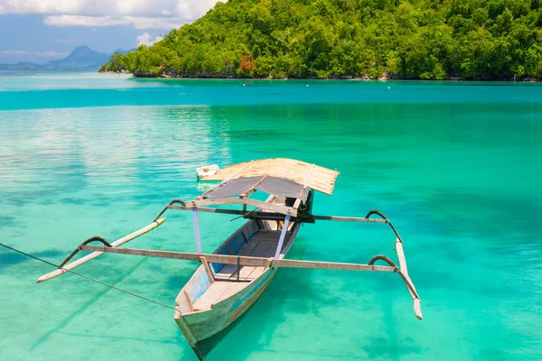Traditionele boot drijvend op de reisbestemming voor transparant blauw afgezwakt lagune van de externe Togean (of Togian) eilanden, Centraal Sulawesi, Indonesië, upgrowing voor jonge hipsters. — Stockfoto