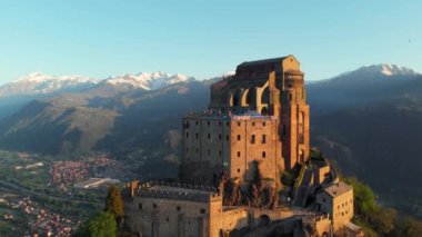 Hava: eski ortaçağ abbey adlı uçan uçak dağın tepesinde, gündoğumu, karlı Alpler'in çarpıcı arka plan üzerinde tünemiş. Sacra di San Michele (İtalyan) - Saint Michel Abbey (İngilizce traslation) - Torino, İtalya
