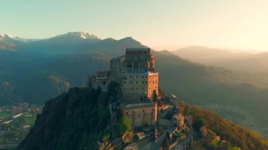 Hava: eski ortaçağ abbey adlı uçan uçak dağın tepesinde, gündoğumu, karlı Alpler'in çarpıcı arka plan üzerinde tünemiş. Sacra di San Michele (İtalyan) - Saint Michel Abbey (İngilizce traslation) - Torino, İtalya