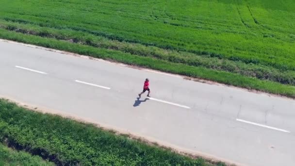 Movimento Lento Aéreo Homem Rastreamento Drones Correndo Sozinho Campo Estrada — Vídeo de Stock