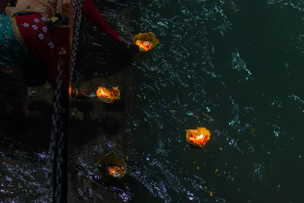 Haridwar, Indie - 20 marca 2017: Święte ghaty w Haridwar, Indie, święte miasto dla religii hinduskiej. Pielgrzymi oferujący pływające kwiaty i palące świece nad rzeką Ganges. — Zdjęcie stockowe
