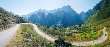 Kuzey Vietnam 'daki Ha Giang karst Geopark Dağı manzarası. Çarpıcı manzarada dolambaçlı bir yol. Ha Giang motosiklet döngüsü, ünlü seyahat yeri motorcuları kolay biniciler.