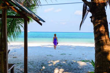 Tropik plajda yürüyen bir kadın. Beyaz kum plajı turkuvazı Karayipler 'in su karayipleri gerçek insanlar. Endonezya Kei Adaları Molucca seyahat noktası.