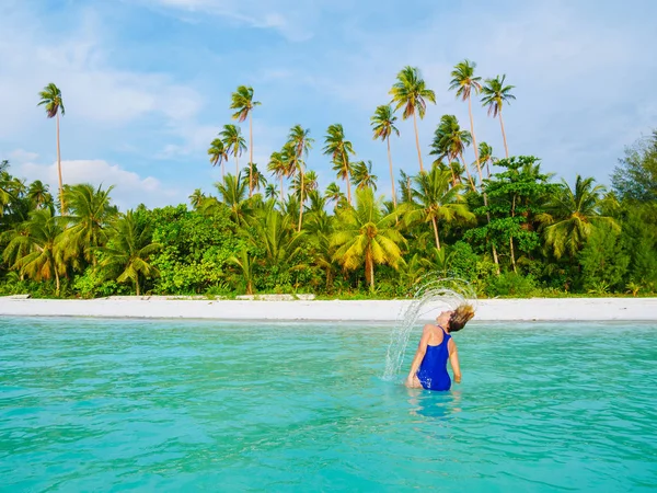 Mulher tomando banho de sol na água transparente turquesa, praia de areia branca, vista traseira, dia ensolarado, pessoas reais — Fotografia de Stock