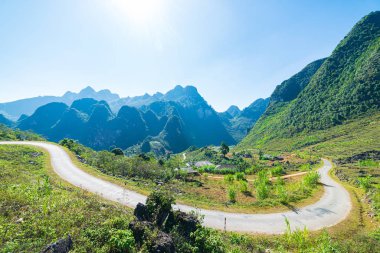 Kuzey Vietnam 'daki Ha Giang karst Geopark Dağı manzarası. Çarpıcı manzarada dolambaçlı bir yol. Ha Giang motosiklet döngüsü, ünlü seyahat yeri motorcuları kolay biniciler.