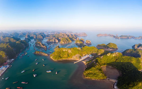 Vista aérea al atardecer de la bahía de Lan Ha y la isla Cat Ba, Vietnam, islas de roca caliza únicas y picos de formación kárstica en el mar, pueblos de pescadores flotantes y granjas de peces desde arriba. Cielo azul claro . — Foto de Stock
