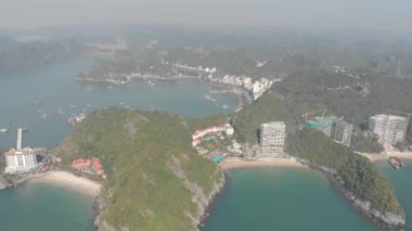 Hava: Cat Ba adasının üstünden genel manzara. Yeni turistik tatil beldeleri ve şehir silüeti olan üç plaj. Ha Long Körfezi, denizdeki eşsiz kireçtaşı zirveleri, Vietnam 'daki seyahat yerleri. yerel d-log sinemasıName