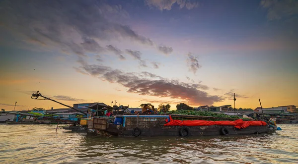 Can Tho, Vietnam - 7 januari 2020: Cai Rang drijvende markt bij zonsopgang, boten verkopen groothandel in fruit en goederen op Can Tho River, Mekong Delta regio, Zuid-Vietnam, toeristische bestemming. Dramatische sk — Stockfoto