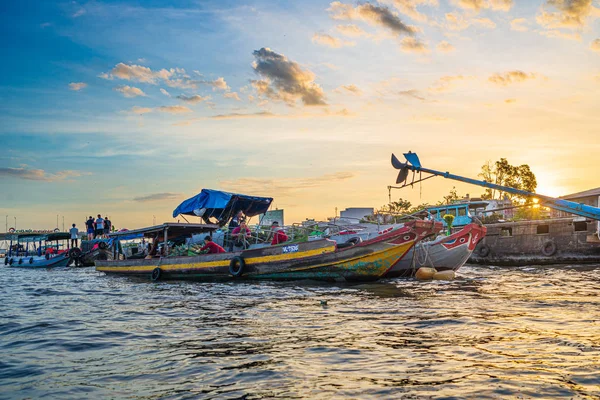 Can Tho, Vietnam - january 7, 2020: Cai Rang floating market at sunrise, boats selling wholesale fruits and goods on Can Tho River, Mekong Delta region, South Vietnam, tourism destination. Dramatic sk — Stock Photo, Image