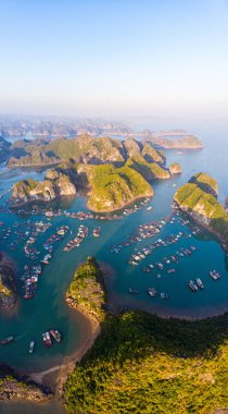 Aerial sunset view of Lan Ha bay and Cat Ba island, Vietnam, unique limestone rock islands and karst formation peaks in the sea, floating fishermen villages and fish farms from above. Clear blue sky. clipart