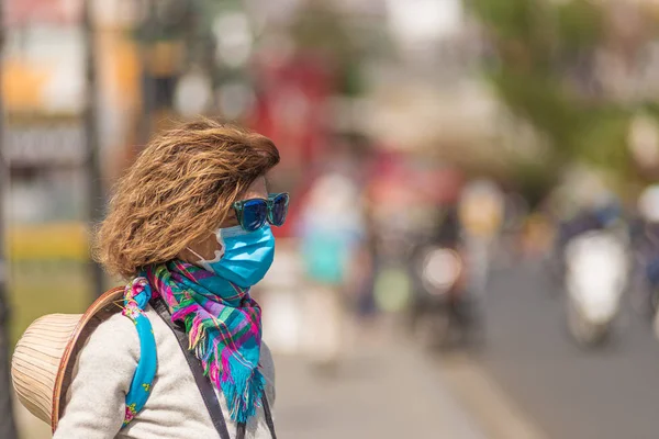 Λευκή γυναίκα με μάσκα υγιεινής στο κέντρο της πόλης Ντα Λατ στο Βιετνάμ. Τουριστικός με ιατρική μάσκα προστασίας από τον κίνδυνο επιδημίας του ιού της γρίπης της Κίνας στην Ασία. Αντιθαμβωτική μάσκα κυκλοφοριακής ρύπανσης. — Φωτογραφία Αρχείου