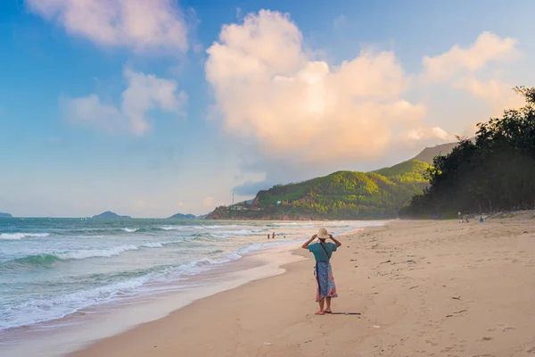 Frau mit traditionellem vietnamesischem Hut beim Blick auf den tropischen Strand. Quy Hoa Quy Nhon Vietnam Reiseziel, Zentralküste zwischen Da Nang und Nha Trang. Herrliche goldene Sandbucht Sonnenuntergang Drama — Stockfoto