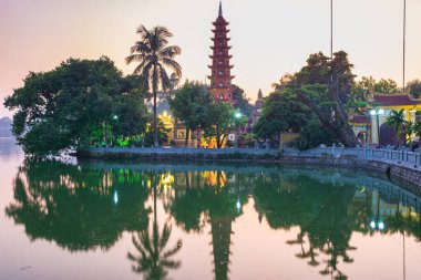 Hanoi Budist tapınağı (Tran Quoc Pagoda) Hanoi 'deki Batı Gölü' nde, renkli günbatımı, aydınlık tapınak, su yansıması. Vietnam seyahati.