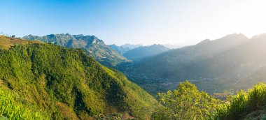 Kuzey Vietnam 'daki Ha Giang karst Geopark Dağı manzarası. Çarpıcı manzarada dolambaçlı bir yol. Ha Giang motosiklet döngüsü, ünlü seyahat yeri motorcuları kolay biniciler.