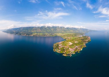Hava: Toba Gölü ve Sumatra Endonezya 'dan Samosir Adası manzarası. Büyük volkanik kaldera suyla kaplı, geleneksel Batak köyleri, yeşil pirinç tarlaları, ekvatoral orman.