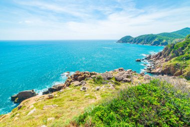 Manzaralı tropik körfezin geniş manzarası, yemyeşil ormanlık ve mavi dalgalı deniz. Vietnam 'ın en doğu kıyısı, Da Nang ve Nha Trang arasındaki Phu Yen bölgesi.. 