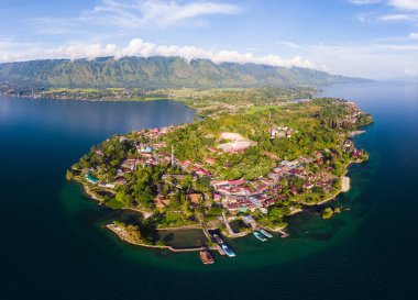 Hava: Toba Gölü ve Sumatra Endonezya 'dan Samosir Adası manzarası. Büyük volkanik kaldera suyla kaplı, geleneksel Batak köyleri, yeşil pirinç tarlaları, ekvatoral orman.