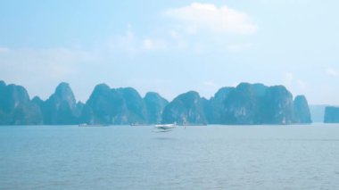 Vietnam 'ın ünlü turizm beldesi Ha Long Körfezi' nde deniz üzerinde uçan bir turizm uçağı. Açık gökyüzü sisi. Sahne kireçtaşı tepeleri denizlerde, karst adaları deniz manzaraları