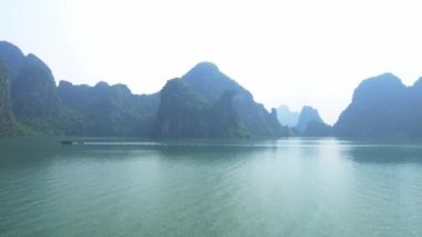 Vietnam 'daki ünlü turizm merkezi Ha Long Bay' in panoramik manzarası. Açık gökyüzü sisi. Sahne kireçtaşı tepeleri denizde, karst adaları deniz manzarası zirvelerinde. Tekne gezisi